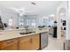 Open concept kitchen with stainless steel dishwasher and view into living room at 2977 White Cedar Cir, Kissimmee, FL 34741