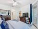 Bright main bedroom features a ceiling fan, dresser, TV, sliding door to patio and ensuite access at 2977 White Cedar Cir, Kissimmee, FL 34741