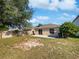 Large backyard with a patio area, green grass, some trees, and a wood fence at 3115 Whispering Trails St, Winter Haven, FL 33884