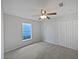Simple bedroom featuring neutral walls, carpet, a ceiling fan, and a window for natural light at 3115 Whispering Trails St, Winter Haven, FL 33884