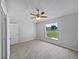 Cozy bedroom featuring a ceiling fan, plush carpeting, and a window that provides ample natural light at 3115 Whispering Trails St, Winter Haven, FL 33884