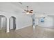 Spacious living room with tile floors, neutral paint, and decorative arches leading to other rooms at 3115 Whispering Trails St, Winter Haven, FL 33884