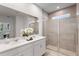 Bright bathroom featuring double sinks with quartz countertops and tiled glass enclosed shower at 3532 Douglas Fir Dr, Apopka, FL 32703
