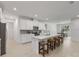 Modern kitchen featuring white cabinets, quartz countertops, stainless steel appliances, and an island with bar stool seating at 3532 Douglas Fir Dr, Apopka, FL 32703