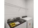 Functional laundry room with a modern Whirlpool washer and dryer set and a wire shelf for storage at 3532 Douglas Fir Dr, Apopka, FL 32703