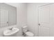 Clean and modern powder room with a pedestal sink, mirror, and toilet with white walls and fixtures at 3532 Douglas Fir Dr, Apopka, FL 32703