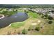 An aerial view of golf course with a tranquil lake and beautifully maintained greens and sand traps at 3660 Ventura Club Cir, Orlando, FL 32822