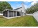 The backyard shows the screened-in patio, well-manicured lawn, and privacy fence at 3660 Ventura Club Cir, Orlando, FL 32822