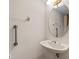 Compact powder room featuring pedestal sink, oval mirror, and safety bars at 3660 Ventura Club Cir, Orlando, FL 32822