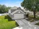 Well-maintained two-story gray home with a two-car garage and landscaped front yard at 3660 Ventura Club Cir, Orlando, FL 32822