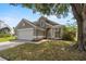 Attractive gray home featuring a two-car garage, arched entry, and established landscaping at 3660 Ventura Club Cir, Orlando, FL 32822