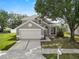 Inviting gray home featuring a two-car garage, mature tree, and well-kept lawn at 3660 Ventura Club Cir, Orlando, FL 32822