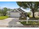 Inviting gray home featuring a two-car garage, arched entry, and well-kept lawn at 3660 Ventura Club Cir, Orlando, FL 32822