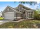 Attractive gray home featuring a two-car garage, arched entry, and manicured front lawn at 3660 Ventura Club Cir, Orlando, FL 32822