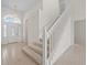 Bright foyer features a decorative glass front door, tile flooring, and a staircase with white railings at 3660 Ventura Club Cir, Orlando, FL 32822