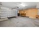 Spacious garage with gray carpeting features an automatic door and a workbench at 3660 Ventura Club Cir, Orlando, FL 32822