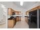 Bright kitchen featuring oak cabinets, dark granite countertops and modern black appliances at 3660 Ventura Club Cir, Orlando, FL 32822