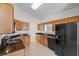 Bright kitchen featuring oak cabinets, dark granite countertops and modern black appliances at 3660 Ventura Club Cir, Orlando, FL 32822