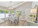 Dining area with a white table, grey chairs, natural lighting, and modern decor, ideal for Gathering meals at 441 S Blue Lake Ave, Deland, FL 32724