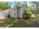 View of the side of the home that includes white fencing, utility connections, and a window at 441 S Blue Lake Ave, Deland, FL 32724