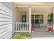 Charming front porch featuring a bench seating area, vibrant flower pots, and a view to the front door at 441 S Blue Lake Ave, Deland, FL 32724
