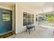 Welcoming front porch featuring a bench, rocking chair, and colorful flower pots, creating an inviting entrance at 441 S Blue Lake Ave, Deland, FL 32724