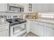 Modern kitchen featuring stainless steel appliances, white cabinetry, and ample counter space for cooking and meal prep at 441 S Blue Lake Ave, Deland, FL 32724