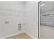 Functional laundry area with hookups and wire shelving, leading to the garage at 443 Marion Oaks Crse, Ocala, FL 34473