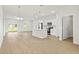 Open-concept living room and kitchen with white cabinets, stainless steel appliances, and abundant natural light at 443 Marion Oaks Crse, Ocala, FL 34473