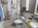 Well-maintained bathroom featuring a marble-patterned shower curtain and granite countertop vanity at 510 Cranes Way # 105, Altamonte Springs, FL 32701
