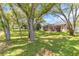 Lush backyard with mature trees and a screened patio area at 572 Lanarkshire Pl, Apopka, FL 32712