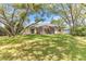 Expansive backyard with mature trees, green grass, and screened-in patio at 572 Lanarkshire Pl, Apopka, FL 32712
