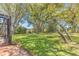 Expansive backyard featuring a lush green lawn, mature trees, and a screened-in lanai perfect for outdoor entertaining at 572 Lanarkshire Pl, Apopka, FL 32712