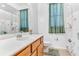 Well-lit bathroom featuring a vanity, toilet, neutral tile, and green accents at 572 Lanarkshire Pl, Apopka, FL 32712