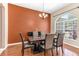 Comfortable dining area with a wood table, seating for six, and an arch-topped window at 572 Lanarkshire Pl, Apopka, FL 32712