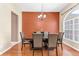 Elegant dining room featuring a dark wood table, leather chairs, and a stylish chandelier at 572 Lanarkshire Pl, Apopka, FL 32712