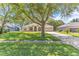 Inviting home with mature trees, landscaped lawn, and an extended driveway leading to an attached garage at 572 Lanarkshire Pl, Apopka, FL 32712