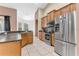Kitchen with stainless steel appliances, wooden cabinets, and a view to the dining room at 572 Lanarkshire Pl, Apopka, FL 32712