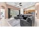 Spacious living room featuring a comfortable gray sectional sofa, ceiling fan, and sliding glass doors to the backyard at 572 Lanarkshire Pl, Apopka, FL 32712