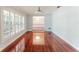 Living area with wood floors, plantation shutters, a ceiling fan, and an entrance to a dining room at 604 Blue Lake Dr, Longwood, FL 32779