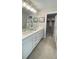 Elegant bathroom featuring double sinks, white cabinetry, and walk in closet at 6450 Horseshoe Lane Way, St Cloud, FL 34773