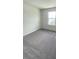 Cozy bedroom featuring plush gray carpet and a bright window for ample natural light at 6458 Horseshoe Lane Way, St Cloud, FL 34773