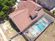 An aerial shot of the backyard pool and patio area, with an overview of the red roof and adjacent yard and fence at 6630 Abeydon Ct, Orlando, FL 32818