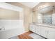 Bright bathroom with double sinks, granite countertops, and soaking tub at 6630 Abeydon Ct, Orlando, FL 32818