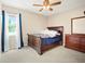 A bedroom with a wooden sleigh bed, dresser, and a window with blue curtains at 6630 Abeydon Ct, Orlando, FL 32818