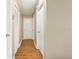 Hallway with wood-look floors and white doors leading to various rooms in the home at 6630 Abeydon Ct, Orlando, FL 32818