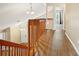 Bright upstairs landing with wood floors and wooden railing overlooking the front door at 6630 Abeydon Ct, Orlando, FL 32818