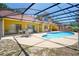 A covered pool with a screen offers outdoor living with a seating area and bar for entertaining Gathering and friends at 6630 Abeydon Ct, Orlando, FL 32818