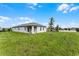 Beautiful backyard showcasing a well-maintained lawn, covered patio, and fresh landscaping at 7155 Cow Prairie Rd, St Cloud, FL 34773