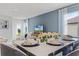 Beautiful dining room with white table setting and flower centerpiece by a window, offering a modern aesthetic at 7155 Cow Prairie Rd, St Cloud, FL 34773